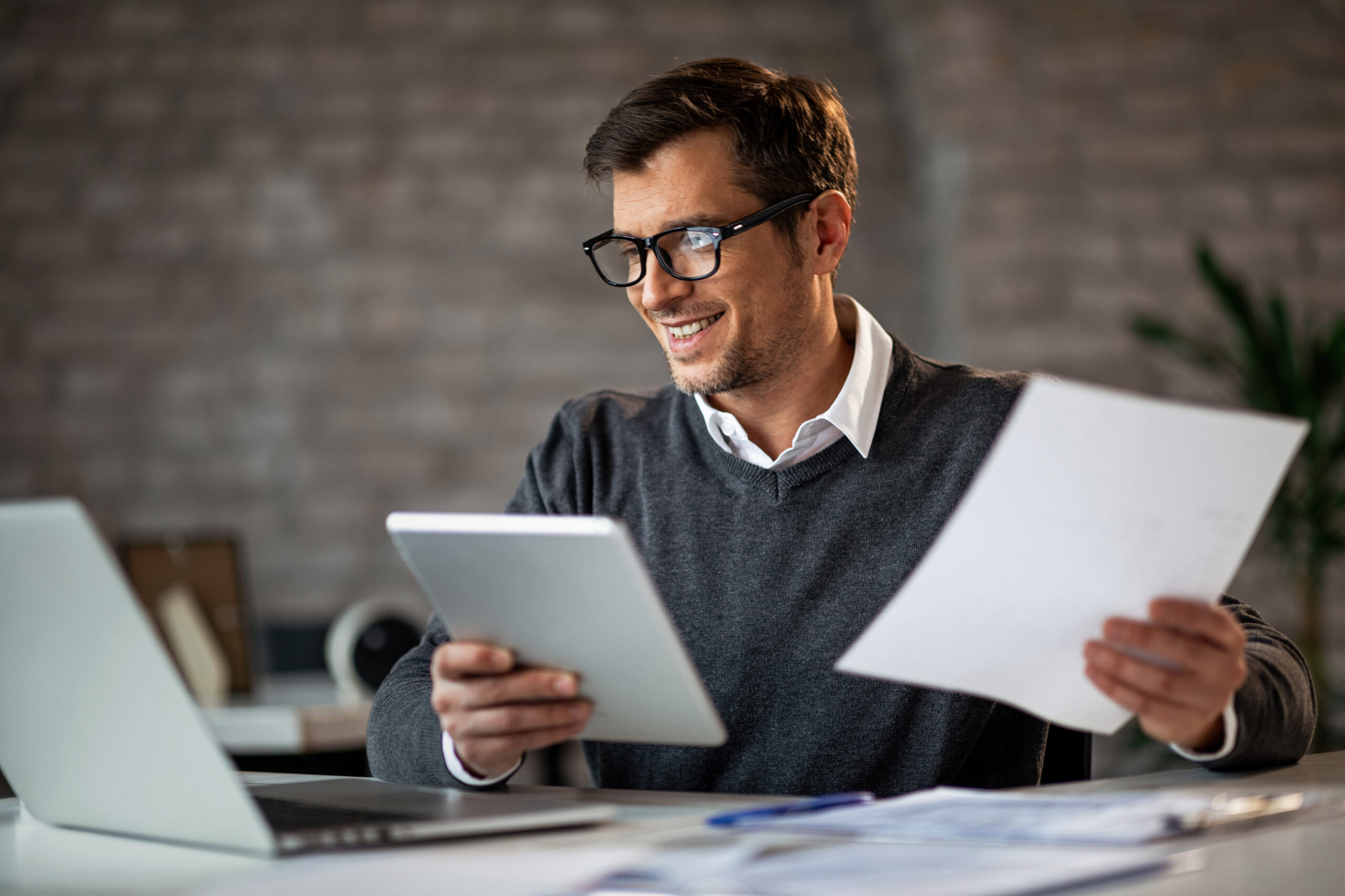 Cliente analisando relatórios de investimentos no notebook, com apoio da consultoria Santo Capital